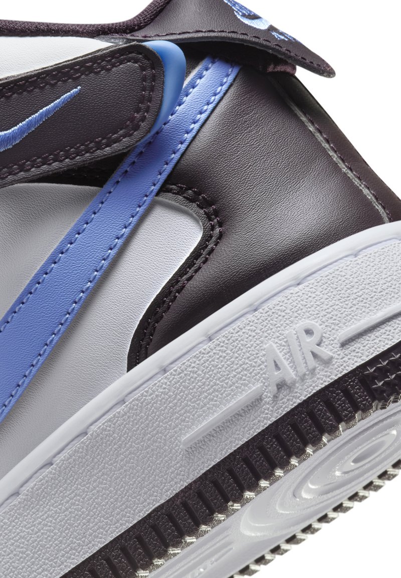 Czarno-białe sneakersy skórzane z niebieskimi akcentami, z rzepem i teksturowaną podeszwą. W środkowej części podeszwy widnieje wytłoczone szczegóły "AIR".