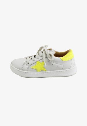 Zapatilla deportiva de cuero blanco con una estrella amarilla en el costado, parche amarillo en el talón, cordones blancos y suela blanca texturizada, vista desde el lado exterior.