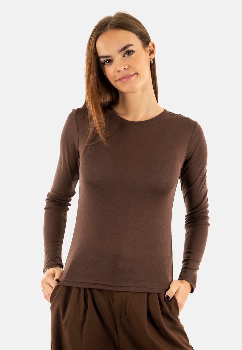 Chemise marron à manches longues en tissu léger et lisse, à la coupe slim et au col rond, portée avec un pantalon marron assorti.