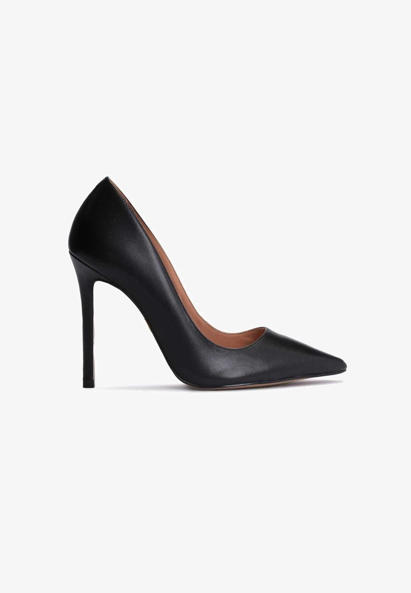 Escarpin à talon haut en cuir noir avec bout pointu, talon aiguille et côtés échancrés, vu de l'intérieur sur fond blanc.