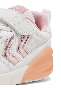 White sneaker with mesh and leather materials, pink accents, metallic rose chevron design, and a translucent orange sole.