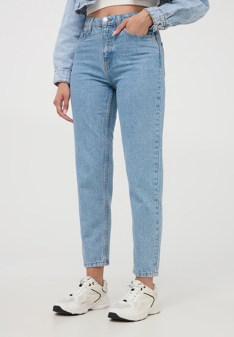 Jeans high-waisted blu chiaro con taglio dritto, caratterizzati da una finitura sbiadita, design a cinque tasche e chiusura con bottone metallico.