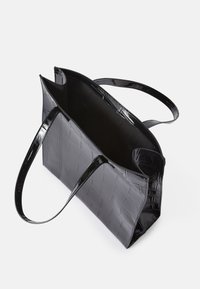 Bolsa tote preta em verniz com textura de crocodilo, abertura superior, e duas alças planas, exibindo um acabamento brilhante e um interior espaçoso.