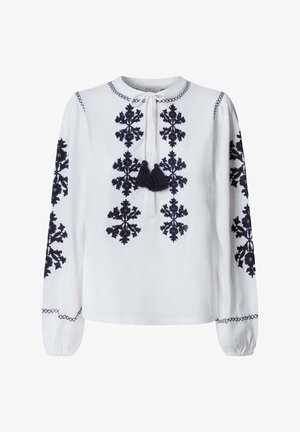 Witte blouse met lange mouwen en zwart ingewikkeld bloemenborduurwerk aan de voorkant en mouwen, voorzien van een ronde hals met strik en kwastjes.