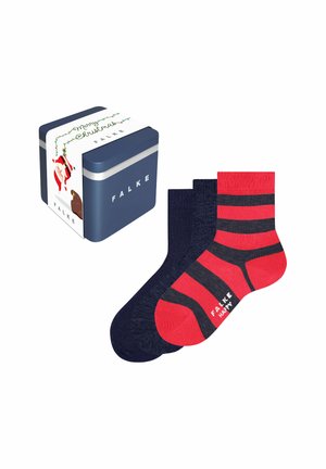 Tre paia di calzini Falke, due blu navy e uno rosso con strisce nere, accanto a una scatola regalo blu navy con confezione a tema natalizio.