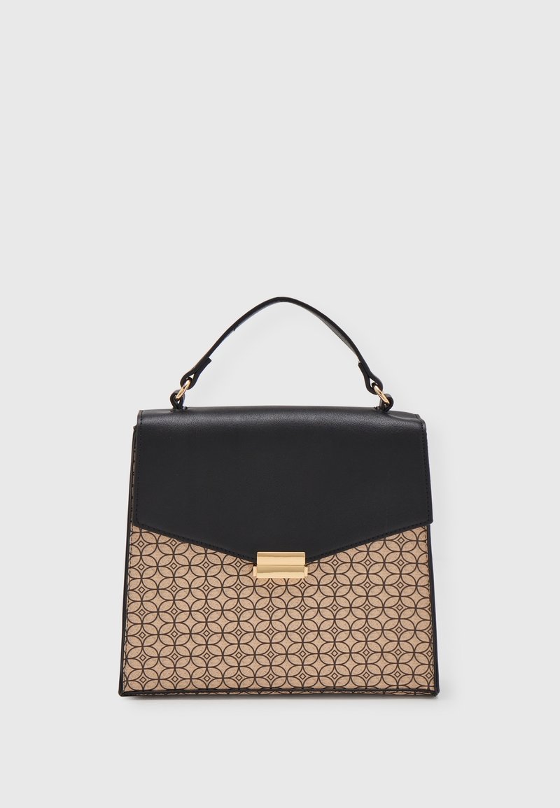 Sac à main noir et beige avec motif géométrique, fermoir doré et anse supérieure unique sur un fond gris clair uni.