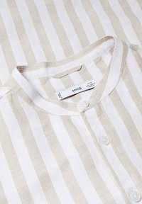 Camisa de lino blanca y beige a rayas verticales con cuello mao y botones blancos, talla mediana, etiquetada como MNG.