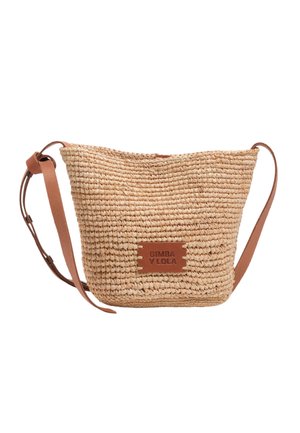 Bolso cesta de paja trenzada con correa de hombro de cuero beige ajustable y pequeño parche de cuero con la etiqueta "BIMBA Y LOLA" en el frente.