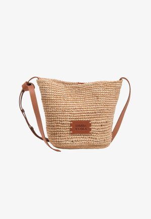 Bolso cesta de paja trenzada con correa de hombro de cuero beige ajustable y pequeño parche de cuero con la etiqueta "BIMBA Y LOLA" en el frente.