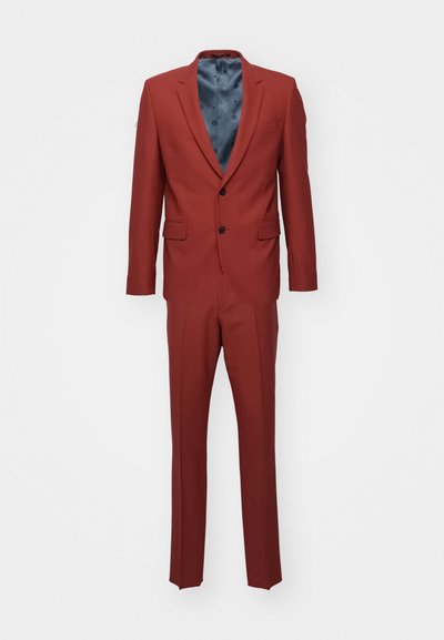 Costume rouge avec un design ajusté, veste à un bouton, fermeture à deux boutons et pantalon à poche plate. Texture lisse, doublure bleue contrastante.