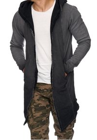 Lange grijze en zwarte hoodie met een versleten ontwerp, voorzien van een volle voorkantopening, textielstof en zijzakken.