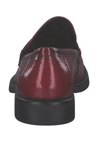 Mocassins en cuir verni rouge avec un bout arrondi et une semelle noire basse. La surface est brillante avec une texture visible et des détails de couture.