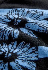 Knit fabric featuring a black base with a floral pattern in light blue. The texture is smooth with intricate detailing in the design.