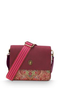 Bordeaux crossbody tas met een gemusterde onderpaneel. Voorzien van een gestreepte roze schouderriem en een ronde decoratieve embleem op de klep.