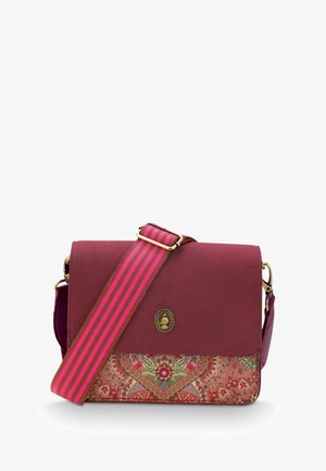 Burgundy crossbody bag with a patterned lower panel. Features a striped pink strap and a round decorative emblem on the flap.