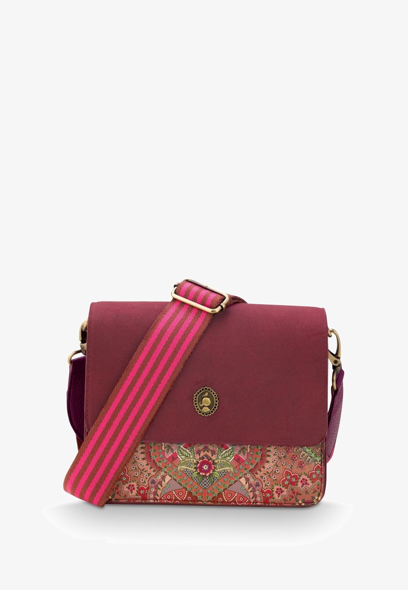 Burgundy crossbody bag with a patterned lower panel. Features a striped pink strap and a round decorative emblem on the flap.