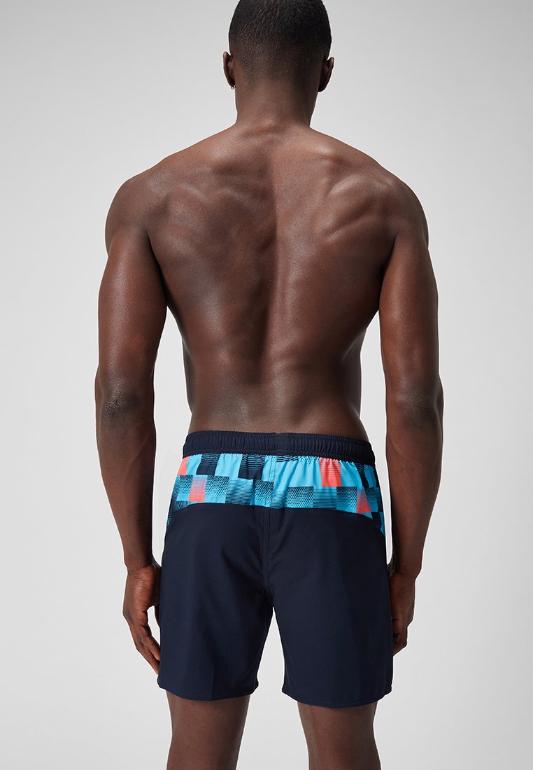 Niebieskie i granatowe kąpielówki z siatką w czerwonym i jasnoniebieskim na pasku. Elastyczny pasek w talii zapewniający komfort i dobre dopasowanie.