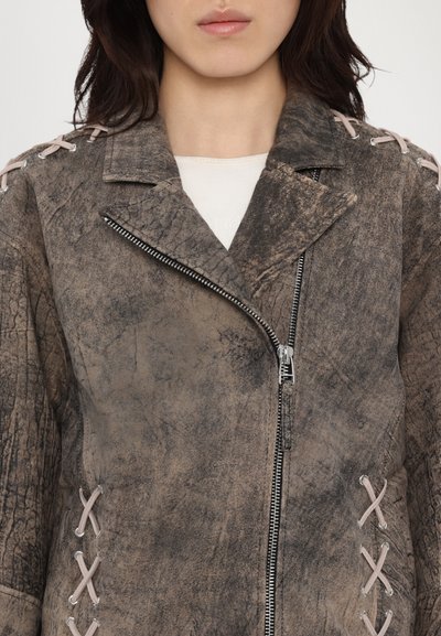 Brun, texturerad läderjacka med en sliten finish. Har dragkedjestängning, slagkrage och rosa snörningsdetaljer på ärmarna.