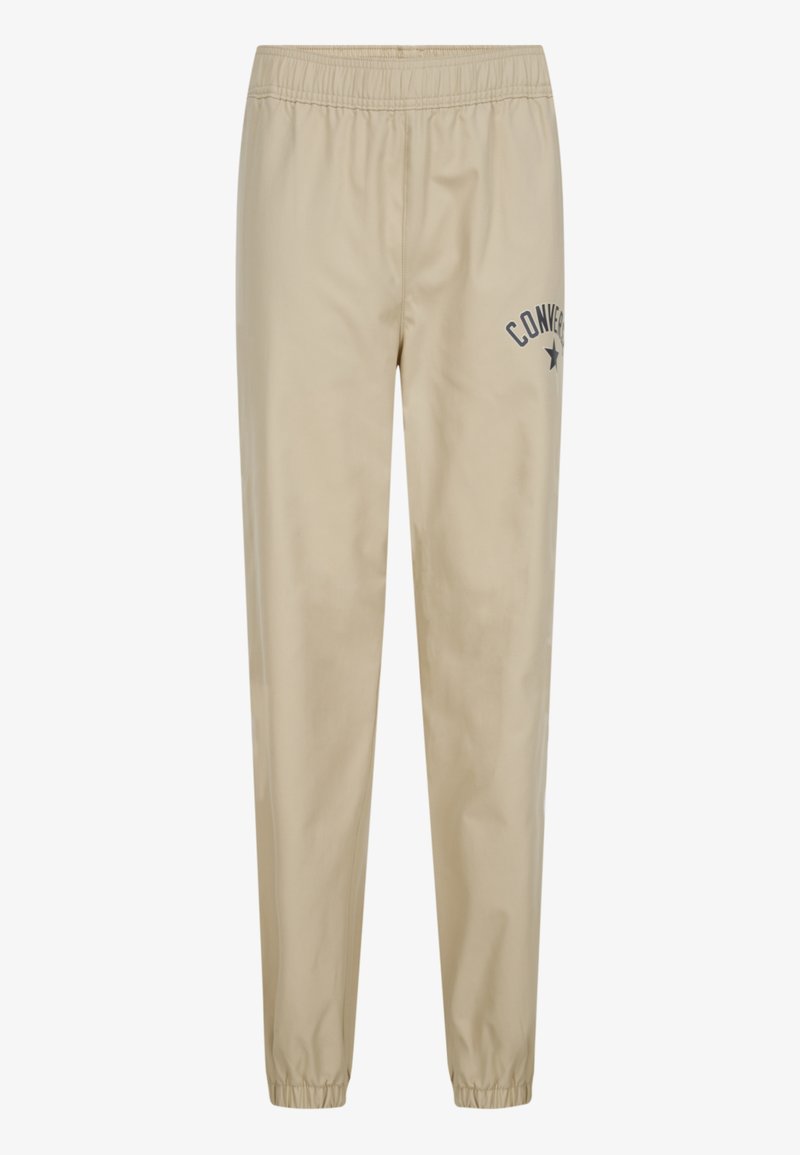 Beige joggerbyxor med elastisk midja, som har en liten marinblå "Converse"-logotyp och stjärna. Slät, lätt tyg, avsmalnande mudd.
