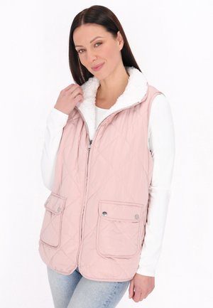 Gestepptes pinkes Westchen mit einem weißen Fleece-Kragen, zwei Fronttaschen und Reißverschluss, getragen über einem weißen Langarmshirt.