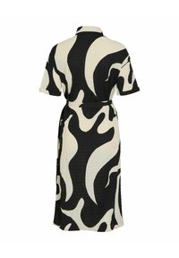 Svart och vit mönstrad klänning med avslappnad passform, korta ärmar, krage och ett tygbälte i midjan. Strukturerat material genom hela plagget.
