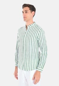 Camicia a maniche lunghe a righe verdi e bianche con colletto a banda e chiusura con bottoni, realizzata in tessuto leggero. Presenta accenti a contrasto ai polsini.