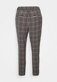 Pantalon fuselé à motif à carreaux noir, marron et blanc, avec deux poches passepoilées à l'arrière et une ceinture élastique.