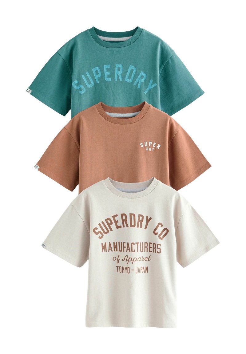 Tre kortærmede t-shirts: grøn med blå tekst, brun med hvid tekst og creme med brun skrift. 100% bomuldsstof, afslappet pasform.