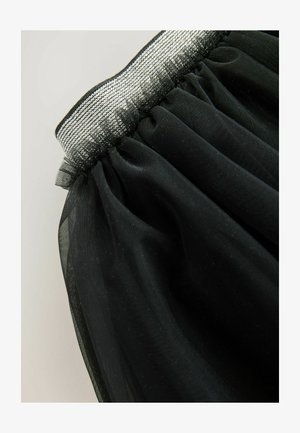 Schwarzer Tüllrock mit einem elastischen Bund, der mit einem silbernen metallischen Rand verziert ist. Der Stoff hat eine weiche, leichte Textur mit geschichteten Rüschen.