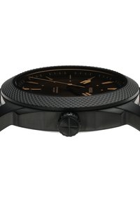 Reloj analógico negro con bisel texturizado, marcadores en tono dorado y una esfera negra sencilla. Cuenta con una corona y una correa metálica. Diseño resistente al agua.