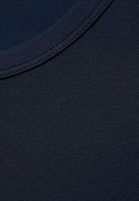 Marinblått texturerat tyg med en mjuk, stickad yta; har en rundad halsringning och tätt vävda fibrer för hållbarhet.