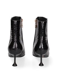 Bottines en simili-crocodile noir avec un design épuré, bout pointu et talons aiguilles élancés. Comprend une fermeture à glissière sur le côté.