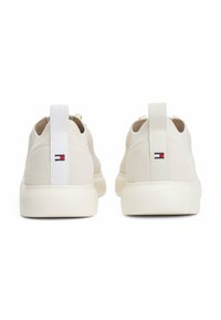Zapatillas deportivas blancas con un material superior suave con un acabado texturizado, puntera redondeada y una lengüeta trasera de contraste con detalles del logo.