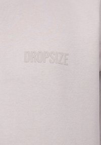Lys gr�å sweatshirt med ribbet tekstur og prægede "DROPSIZE" logo i midten. Mellemvægtigt stof, afslappet design.