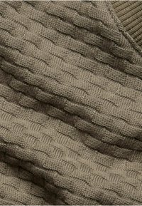 Strikket sweaterstof i en dæmpet beige farve med et struktureret kurv vævs mønster og ribbede kanter.