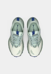 Heled roheline spordijalats, millel on tekstuuriga viimistlus, sinised aktsendid, mustrilised katteid ja paindlik tallaga, millel on hallid paelad ja kontsainad.