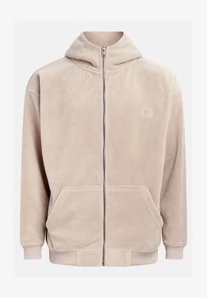 Bežs flīsa kapuci ar pilnu rāvējslēdzēju, kapuci un divām priekšējām kabatām. Iezīmē ribotās piedurknes un izšuvumu uz kreisā krūšu.