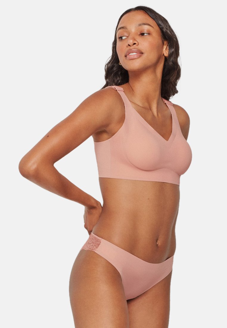 Conjunto de sujetador y braguitas de color rosa claro, hecho de una tela suave, que presenta un diseño de escote en V y un detalle de encaje en el lateral de la braguita.