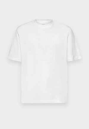T-shirt bianca in cotone con un design del logo a quadrato in rilievo, con dettagli "A|X" e "ARMANI EXCHANGE BLACK EDITION 2.0" sul davanti.