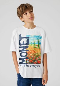Camiseta blanca que presenta una colorida pintura de Monet de un campo con flores. El texto dice "MONET" y "El arte es para todos" en azul marino.