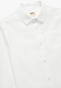 Witte lange mouwen shirt voor kinderen, gemaakt van katoen. Voorzien van een button-down kraag, een borstzak en een regular-fit ontwerp. Soepele textuur.
