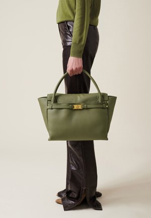 Sac à main en cuir vert au design structuré, doté d'un fermoir en métal doré et de deux poignées arrondies, sur un fond neutre.