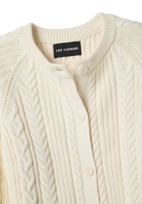 Cardigan crème en maille torsadée avec encolure ronde, fermeture à boutons sur le devant, et étiquette "LES COPAINS" à l'intérieur du col.