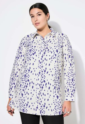 Camicia bianca con motivo a macchie viola, maniche lunghe, chiusura a bottoni sul davanti e due tasche sul petto. Realizzata in tessuto di cotone.