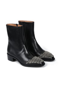 Czarne skórzane botki za kostkę z wysoką, gładką cholewką. Kwadratowe noski ozdobione metalowymi ćwiekami ułożonymi w wzór trójkąta. Słupkowe obcasy.