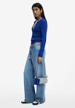 Blue ribbed knit cardigan with a collar, paired with wide-leg light wash denim jeans. Accessories include a textured snake print bag.