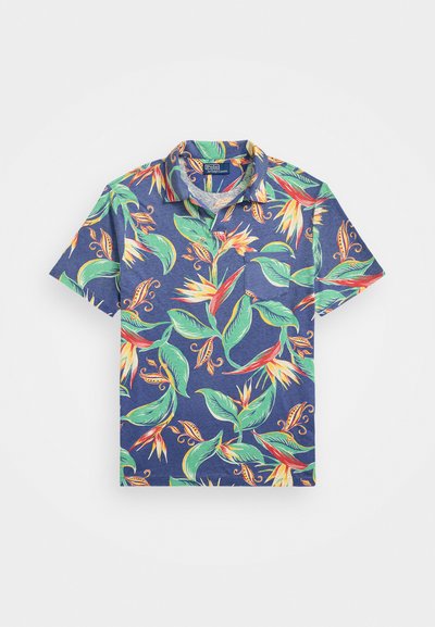 Polo majica s kratkimi rokavi v mornarsko modri tkanini, ki vsebuje živahen cvetlični vzorec z zelenimi listi ter rdečimi in rumenimi cvetovi.