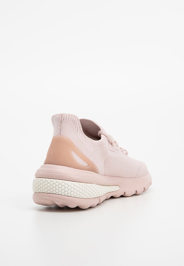 Scarpe sportive rosa chiaro con tomaia in maglia, controcanto testurizzato e una suola intermedia spessa di colore bianco con un motivo a nido d'ape.