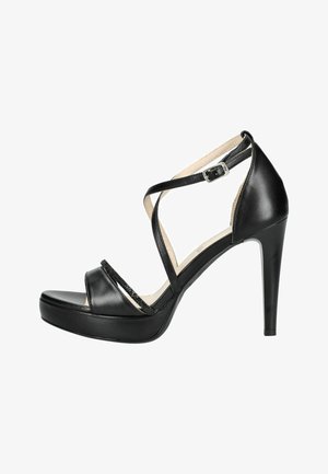 Sandalo nero con tacco alto e suola platform, punta aperta, sottili cinturini incrociati sul piede e fibbia alla caviglia.
