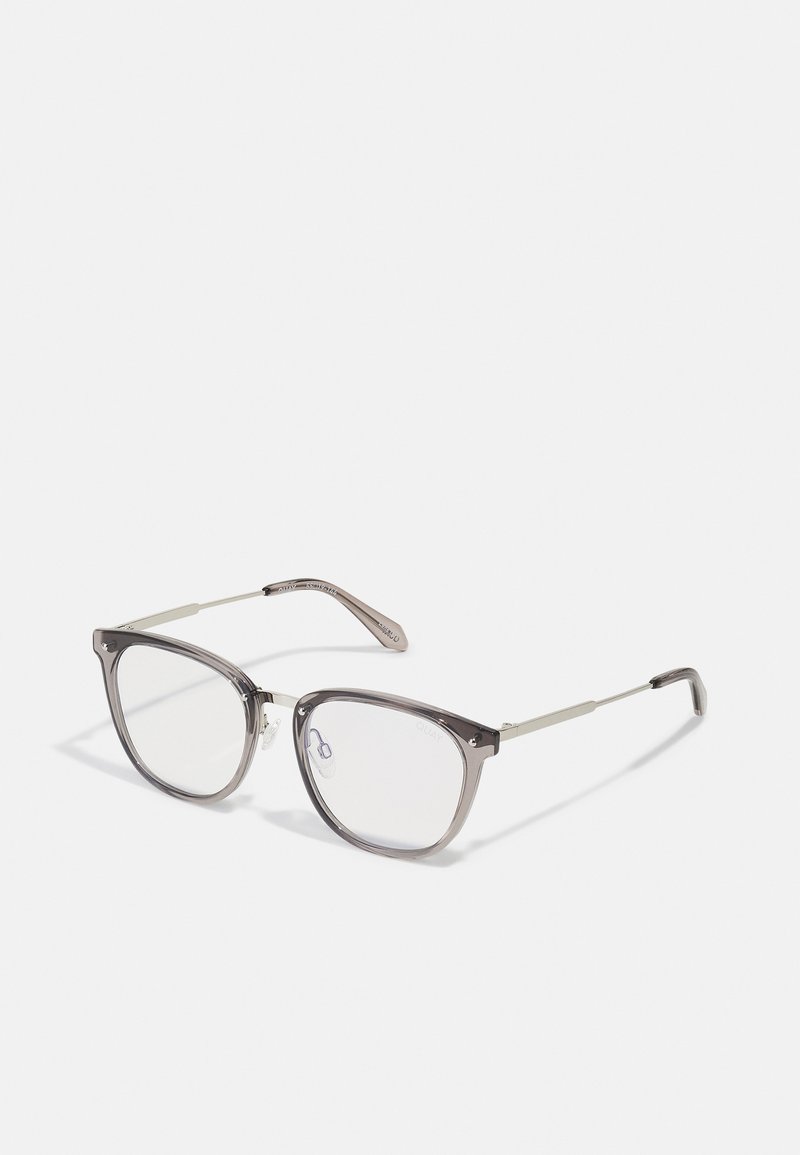 Gafas con una montura de plástico gris transparente, acentos metálicos plateados y lentes transparentes. Presentan una forma de ojo de gato y detalles en las varillas.
